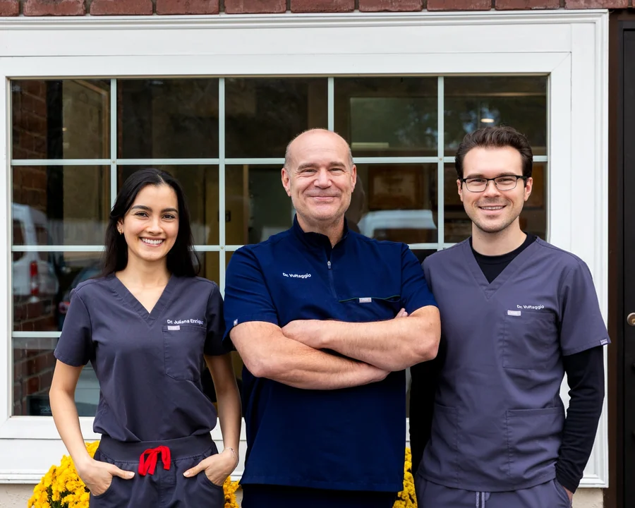 Dr. Juliana Enriquez, Dr. Stephen Vultaggio and Dr. Andrew Vultaggio standing together outside a brick building.