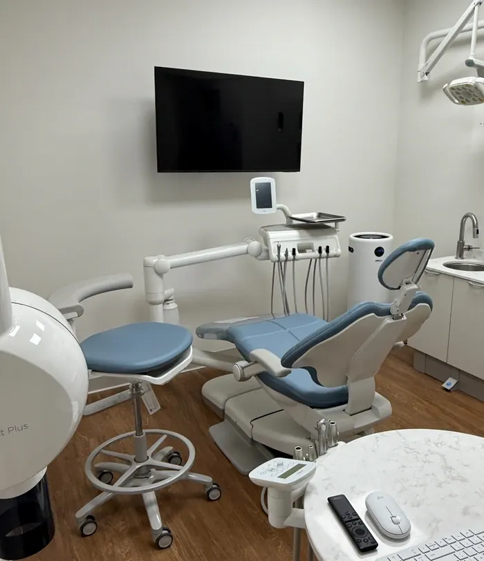 A treatment room at Vultaggio Dental with a dental chair and a television above it.